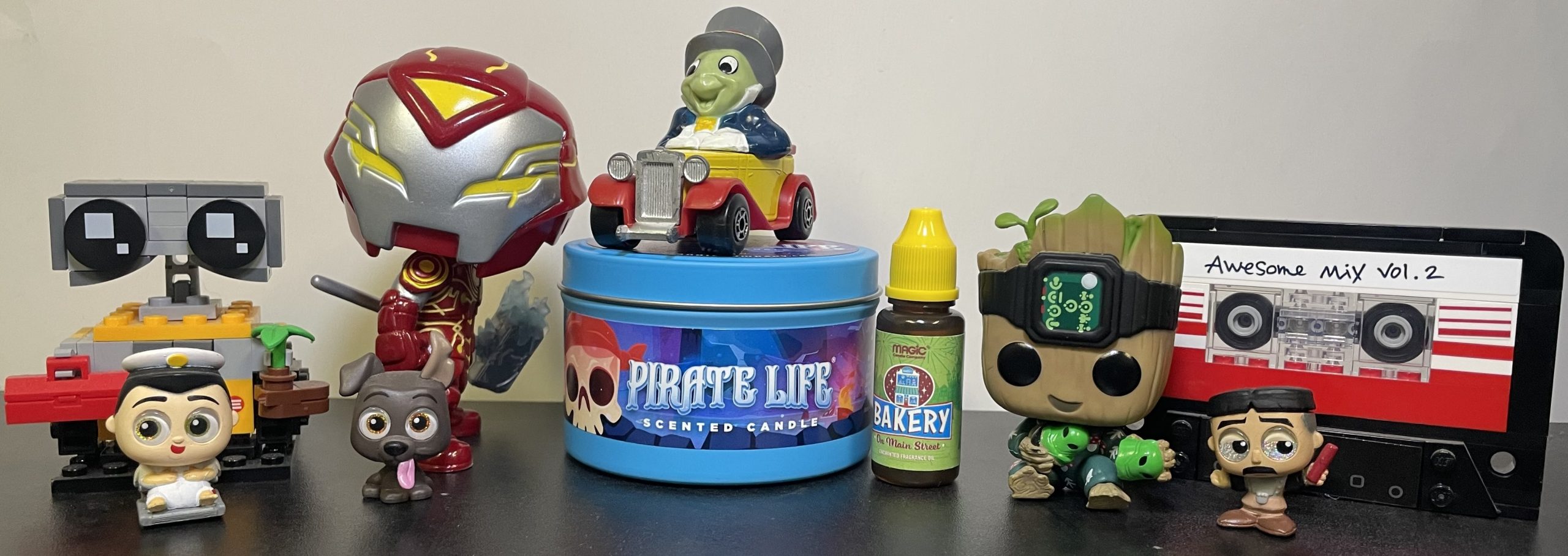 Disney characters, Disney figurines, and Disney-themed products. Pixar's WALL-E, Pixar's Captain B. McCrea, Marvel's Iron Man, Pixar's Dante the dog from Coco, Disney's Jiminy Cricket, Disney Pirates of the Caribbean candle, Disneyland bakery on Main Street Disney diffuser oil, Marvel's Groot, Marvel's Guardians of the Galaxy Mixtape Volume 2